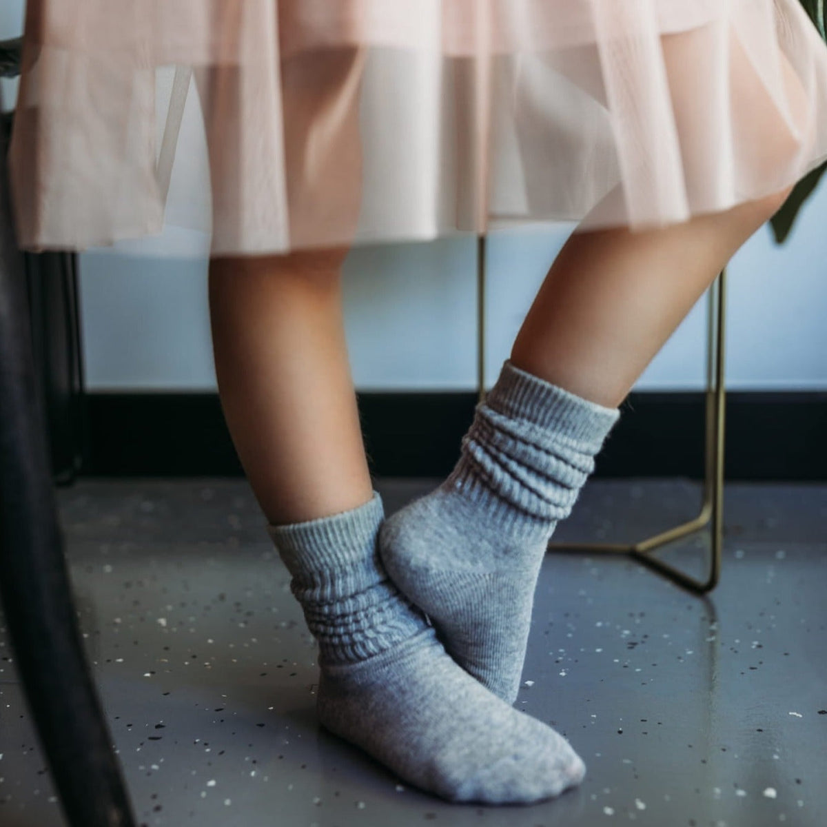 Grijze Dream Socks sokken van Mama's Feet, gedragen door een kind onder een lichtroze rok