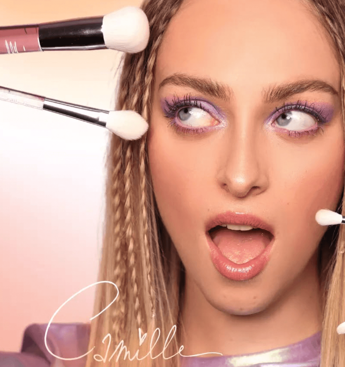 Camille met paarse oogmake-up en verschillende make-upkwasten rond haar gezicht, waaronder de Blusher Brush.