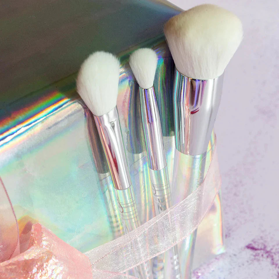 Blusher Brush uit de Camille-collectie naast twee kleinere make-upkwasten in een holografische verpakking met strik.