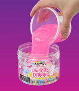 Felroze Unicorn Dream-slijm wordt uit een bakje in de pot gegoten tegen een paarse achtergrond.