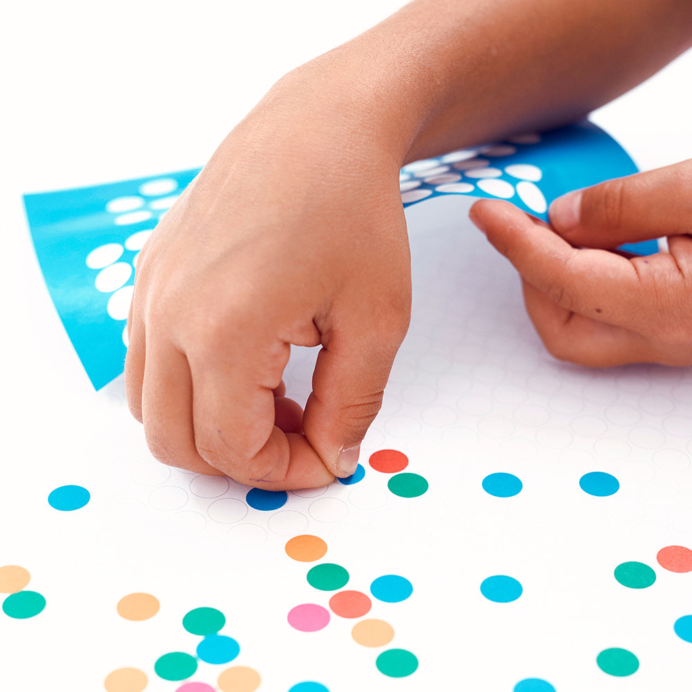 Handen plakken ronde, gekleurde stickers op een Dot On poster met voorgedrukte cirkels