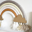 DIY regenboog Nude met bogen in zachte tinten, kartonnen wolken en witte, crème en taupekleurige kwastjes.