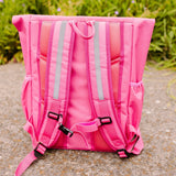 Achterkant van de roze Flashbag Lou-rugzak met verstelbare schouderbanden, reflecterende stroken en borstclip.