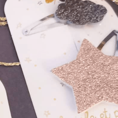 Detail van haarspelden met een rosékleurige glitterster en een bronzen glitterwolk.
