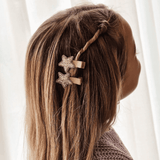 Twee haarspeldjes Glitter Star met goudkleurige glittersterren in het gedraaide haar van een kind.