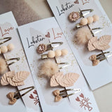 Drie sets Summer Vibes haarspeldjes op kaartjes, met roze bloemen, bolletjes, pluizige pompons, blaadjes en strikjes.