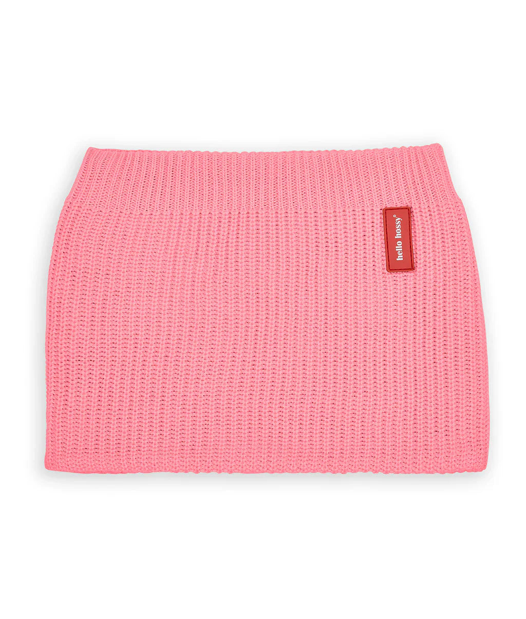 Roze gebreide Cocoon Pink nekwarmer van Hello Hossy met rood merklabel op een witte achtergrond.
