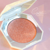Camille highlighter met glinsterend roze poeder in een open diamantvormig doosje op een roze achtergrond.