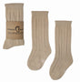Beige Helen kniekousen van Mama's Feet met opengewerkt patroon, los en met papieren wikkel.
