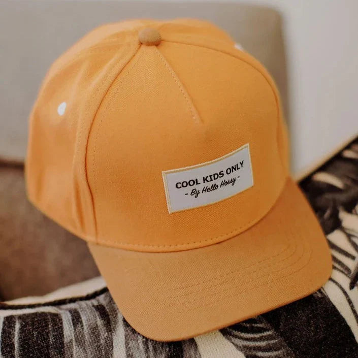 Hello Hossy Mini Tan pet met het label ‘Cool kids only’, liggend op een zwart-wit patroon.