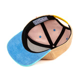 Binnenkant van de Sweet Peach pet met zwarte banden, blauwe onderkant van de klep en gele sluiting.
