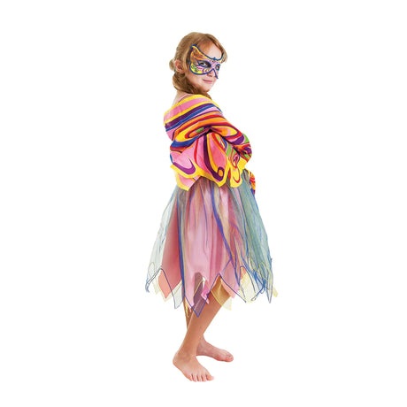 Kind in regenboogjurk met kleurrijke vleugels om de schouders en een bijpassend masker, van opzij gezien.