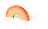 Regenboogvormig stoepkrijt met oranje, gele en lichtgroene banen op een witte achtergrond.