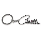 Zilverkleurige sleutelhanger met de naam Camille en een hartje met roze pareltje op de i.