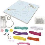 Inhoud van de Unicorn String Art set met eenhoornbordje, zeven kleuren garen, pinnetjes, versieringen en batterijhouder.