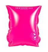 Neonroze zwembandje in close-up, met een transparant opblaasventiel rechtsonder.